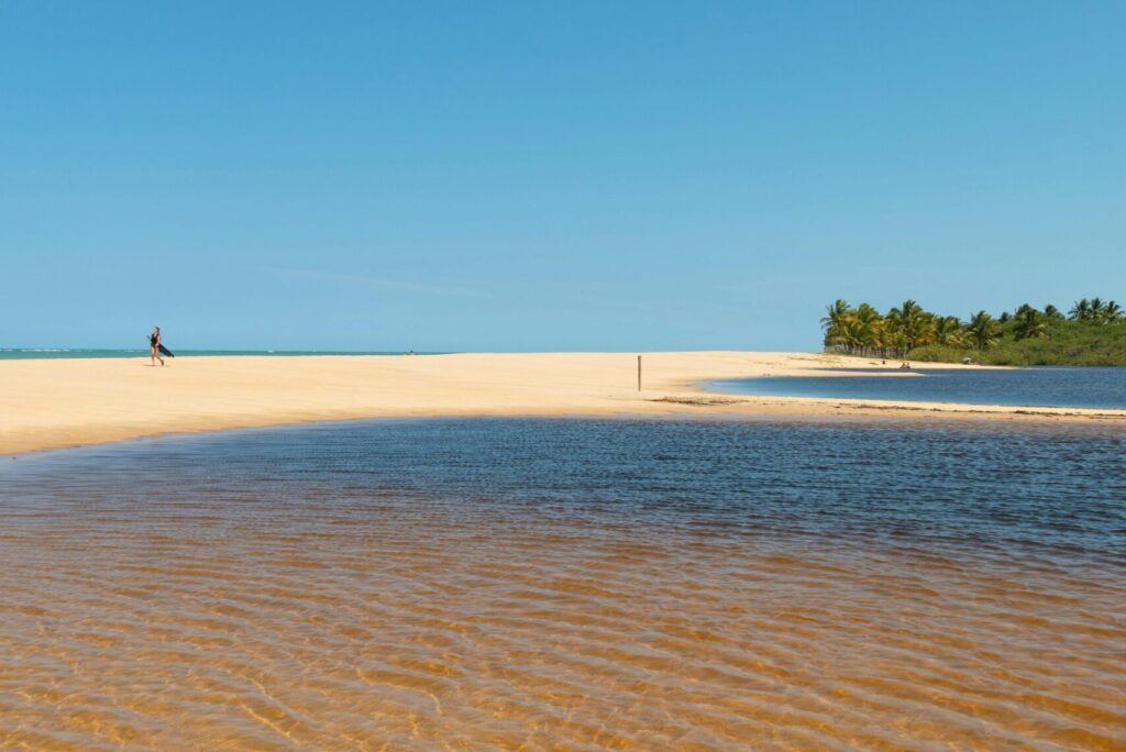 Idyllic beach scene with clear waters and blue sky in Trancoso, Brazil.